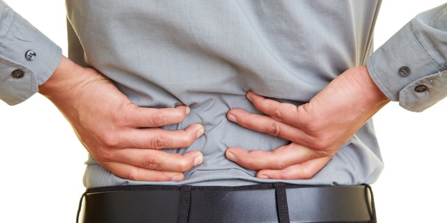 Man standing with pain in his back