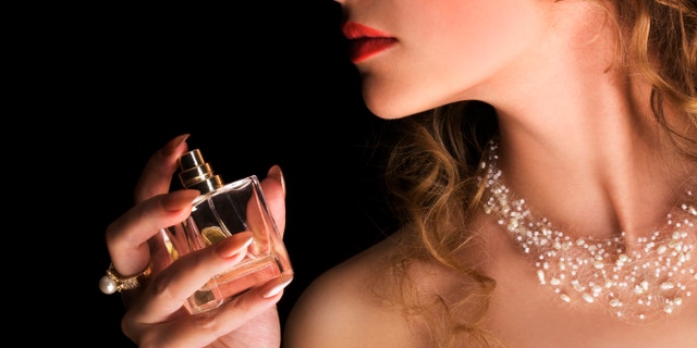 Beauty applying perfume on her neck