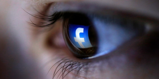 A picture illustration shows a Facebook logo reflected in a person's eye, in Zenica, March 13, 2015. (REUTERS/Dado Ruvic)