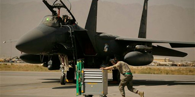 In this Oct. 17 picture, a U.S. Air Force airman passes an F-15E Strike Eagle at Bagram Air Field in Afghanistan. (AP Photo)