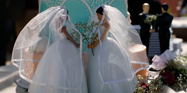 Same-sex female and male wedding cake toppers are seen outside the East Los Angeles County Recorder's Office on Valentine's Day during a news event for National Freedom to Marry Week in Los Angeles, California February 14, 2012. Same-sex marriage has not been restored in California though earlier this month the United States Court of Appeals for the Ninth Circuit declared California's ban on same-sex marriage, known as Proposition 8, unconstitutional. A 2008 California Supreme Court decision allowed same-sex couples to marry until Proposition 8 was passed. REUTERS/David McNew (UNITED STATES - Tags: SOCIETY)