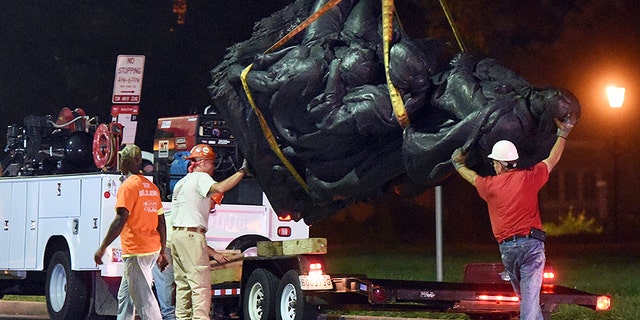 Workers remove a monument dedicated to the Confederate Women of Maryland early Wednesday, Aug. 16, 2017, after it was taken down in Baltimore. Local news outlets reported that workers hauled several monuments away, days after a white nationalist rally in Virginia turned deadly. (Jerry Jackson/The Baltimore Sun via AP)