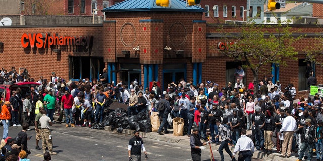 Police and demonstrators gather in the aftermath of rioting following the funeral for Freddie Gray, who died in police custody, on April 28, 2015, in Baltimore.