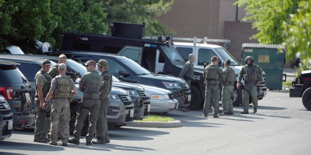 Tactical police stage in a Safeway parking lot on Belair Road near Chapel Road in response to the death of a Baltimore County police officer in Perry Hall, Md., May 21, 2018.