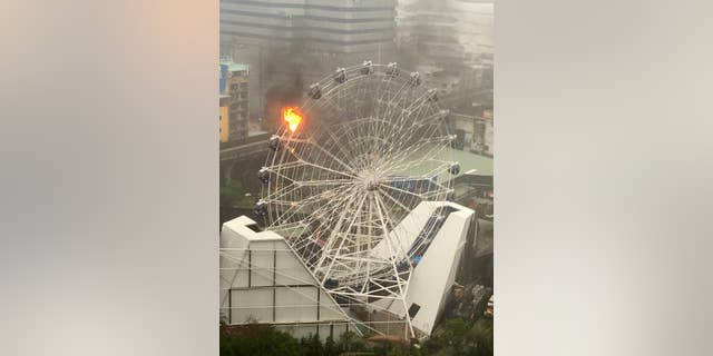 An empty passenger car of a Ferris wheel burns at Dinosaur Planet in Bangkok, Thailand on April 30, 2016.
