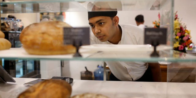 Dwin Islam Rakib, a survivor of the July 1 attack at Holey Artisan Bakery, works at the reopened restaurant in Dhaka, Bangladesh, Thursday, Jan. 12, 2017. The Bangladesh cafe besieged by militants who killed 20 hostages last year has quietly reopened in a shopping mall a few blocks from its old, bloodied site. Staff members said this week's reopening of the Holey Artisan Bakery represents a new beginning. (AP Photo)