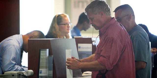 PASADENA, CA - JULY 14: Customers (R) carry out their transactions with tellers after waiting in line with hundreds of other nervous customers to get into an IndyMac Bank, open for the first time since the July 11 federal government takeover of the thrift, on July 14, 2008 in Pasadena, California. IndyMac, which was already in trouble because of it's subprime mortgages with people with bad or no credit history, was shut down three hours early on a Friday and remained closed over the weekend after customers withdrew $1.9 billion. Regulators say it is the second-largest bank failure ever in the US. As all 33 IndyMac branches reopen, customers with home-equity credit lines will reportedly find their accounts frozen while transactions involving deposit accounts will be conducted as normal under the name, IndyMac Federal Bank. Over the weekend, the Federal Reserve also worked on shoring up lenders Fannie Mae and Freddie Mac which control almost half of the national mortgage debt and are in danger of collapse as well. (Photo by David McNew/Getty Images)