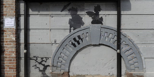 Oct. 19, 2013: Work by British graffiti artist Banksy is displayed in the Brooklyn borough of New York. The building owner has hired security guards and installed a metal gate to protect a work by Banksy. Cara Tabachnick, whose family owns the building, said the goal is to preserve the artwork "so it can be viewed and enjoyed." Most of the Banksy works that have gone up have been tagged over by others, and some have been completely erased. Mayor Michael Bloomberg said last week that graffiti ruins property and is "a sign of decay." (AP/Alyssa Goodman)