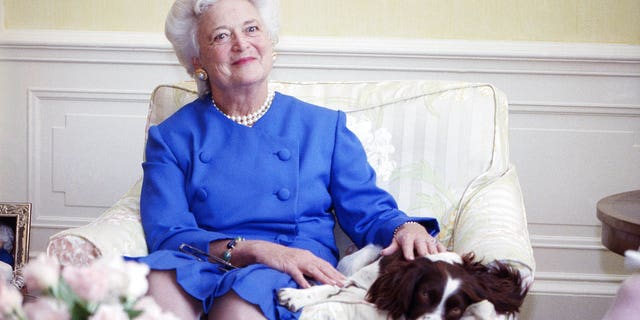FILE - In this 1990 file photo, first lady Barbara Bush poses with her dog Millie in Washington. A family spokesman said Tuesday, April 17, 2018, that former first lady Barbara Bush has died at the age of 92. (AP Photo/Doug Mills, File)