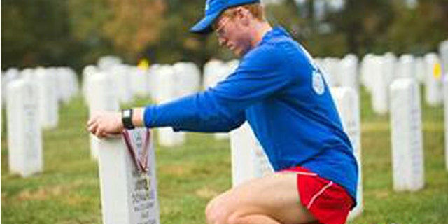 Seamus Donahue, 18, places his Marine Corps Marathon finisher’s medal on the grave of his father, Maj. Michael Donahue, at Arlington National Cemetery on Oct. 25, 2015. Seamus ran the marathon in honor of his father who was killed in Kabul, Afghanistan on Sept. 16, 2014.