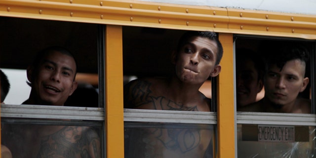 Members of the Barrio 18 Gang wait on a bus as 1282 inmates are transferred from the cojutepeque jail in Cojutepeque, El Salvador