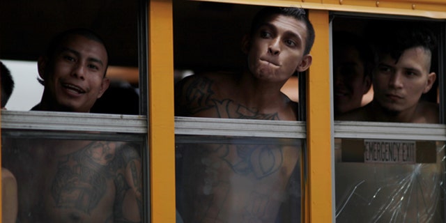 Members of the Barrio 18 Gang wait on a bus as 1282 inmates are transferred from the cojutepeque jail in Cojutepeque, El Salvador