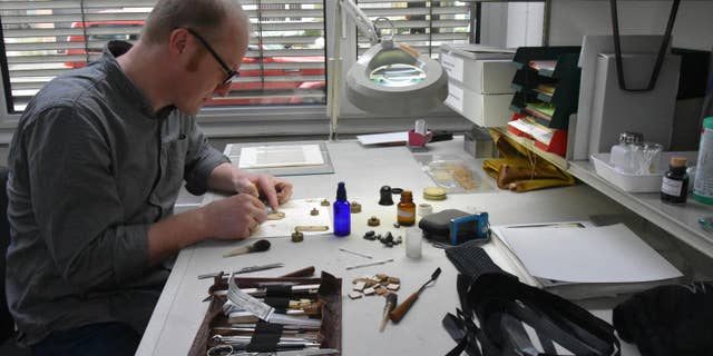 An expert works on the ancient papyrus.