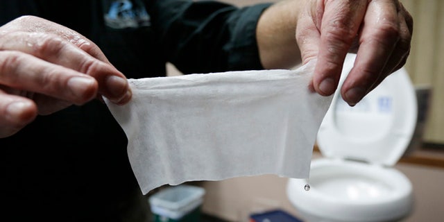 Sept. 20, 2013: In this photograph taken in Middlesex, N.J., Rob Villee, executive director of the Plainfield Area Regional Sewer Authority in New Jersey, holds up a wipe he flushed through his test toilet in his office. Increasingly popular bathroom wipes, thick, premoistened towelettes that are advertised as flushable, are creating clogs and backups in sewer systems around the nation.