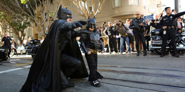 November 15, 2013. Five-year-old leukemia survivor Miles Scott, dressed as Batkid arrives with Batman to rescue a woman in distress as part of a day arranged by the Make- A - Wish Foundation in San Francisco, California. The young cancer survivor will be treated to various super hero scenarios including receiving a commendation at San Francisco City Hall.