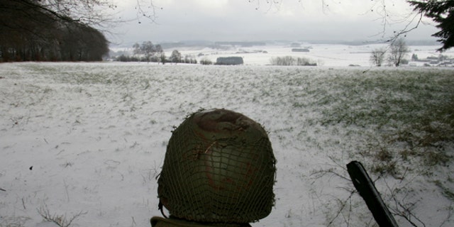 A man dressed as a U.S. soldier looks at the site of the Battle of the Bulge before a ceremony at the Mardasson World War II memorial monument in Bastogne, Dec. 18, 2004.