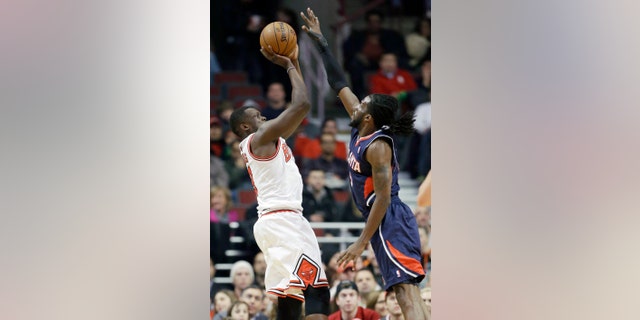 Chicago Bulls forward Luol Deng, left, shoots over Atlanta Hawks forward DeMarre Carroll during the first half of an NBA basketball game in Chicago on Saturday, Jan. 4, 2014. (AP Photo/Nam Y. Huh)