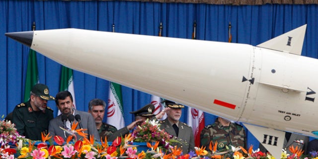 April 18: Iranian President Mahmoud Ahmadinejad, second left, listens to his Defense Minister, Gen. Ahmad Vahidi, as a rocket is paraded during National Army Day.