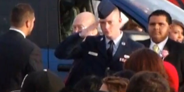 In this still image taken from an April 20, 2013 video provided by Tammy Garth, Airman Cassey Widener salutes as his sister, Courtrney Widener, arrives for prom at Liberal High School in Liberal, Kan. Courtney wanted her brother, recently returned from Afghanistan, to escort her to front door of the school, but school officials denied her request stating that at 22, he was too old to participate. The high school principal that barred Airman Cassey Widener from escorting his sister to prom has apologized, saying the intent was not to dishonor him. Deputy Superintendent Paul Larkin said Tuesday, April 30, 2013 that a policy change allowing exceptions to the age restriction will be presented at Monday’s school board meeting. (AP Photo/Tammy Garth)