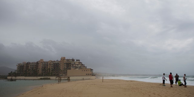 People watch the sea at El Medano Beach before the arrival of Hurricane Blanca, in Cabo San Lucas, Mexico, Sunday June 7, 2015. (AP Photo/Eduardo Verdugo)