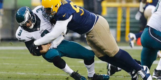 Green Bay Packers' Letroy Guion sacks Philadelphia Eagles' Mark Sanchez during the first half of an NFL football game Sunday, Nov. 16, 2014, in Green Bay, Wis. (AP Photo/Mike Roemer)