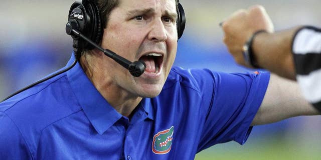 FILE - In this Sept. 28, 2013, file photo, Florida head coach Will Muschamp yells to an official in the second quarter of an NCAA college football game against Kentucky in Lexington, Ky. Muschamp came to his own defense Wednesday, Sept. 3, 2014, ripping critics who questioned his decision to reinstate three players suspended for a season opener that lasted just 10 seconds. (AP Photo/James Crisp, File)