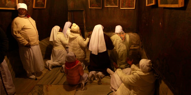 Christian pilgrim worshippers from Nigeria pray in the Grotto of the Church of Nativity, traditionally believed by Christians to be the birthplace of Jesus Christ, in the West Bank town of Bethlehem on Christmas Eve, Dec. 24, 2013.