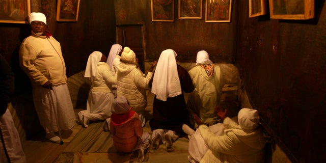 Christian pilgrim worshippers from Nigeria pray in the Grotto of the Church of Nativity, traditionally believed by Christians to be the birthplace of Jesus Christ, in the West Bank town of Bethlehem on Christmas Eve, Dec. 24, 2013.