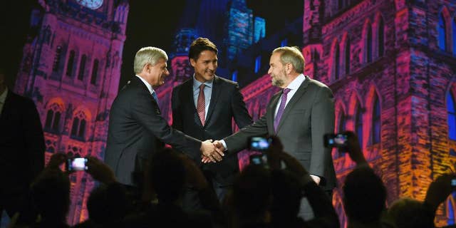 New Democratic Party leader Tom Mulcair, right, shakes hands with Conservative Prime Minster Stephen Harper, left, as Liberal leader Justin Trudeau, center, looks on during their introduction prior to a debate, Thursday, Sept. 17, 2015 in Calgary, Alberta. (Sean Kilpatrick/The Canadian Press via AP) MANDATORY CREDIT