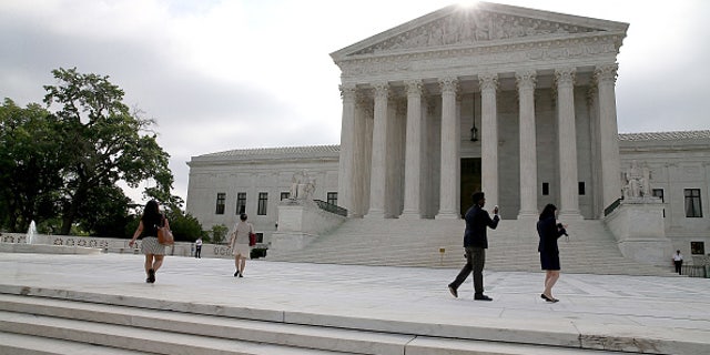 WASHINGTON, DC - JUNE 18: People gather in front of the Supreme Court Building as the high court is expected to hand down its ruling on gay marriage and Obamacare subsidies.