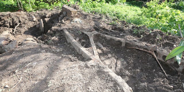 The frame and engine can be clearly identified, while much of the rest of the car has rotted away.