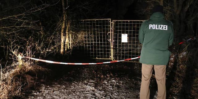 A police officer stands in front of a closed off entrance to a private ground near Arnstein, Germany, Sunday Jan. 29, 2017. Police in Germany say the bodies of six teenagers have been found dead in a garden house near the southern city of Wuerzburg. (Daniel Karmann/dpa via AP)
