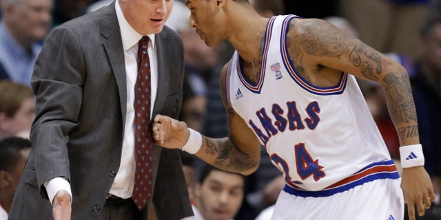 Kansas coach Bill Self talks with guard Travis Releford (24) during the first half of an NCAA college basketball game against TCU in Lawrence, Kan., Saturday, Feb. 23, 2013. (AP Photo/Orlin Wagner)