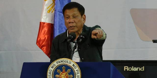 FILE - In this Thursday, June 30, 2016, file photo, Philippine President Rodrigo Duterte gestures as he delivers his speech before a solidarity dinner with the poor event at a slum area in Manila, Philippines. New Philippine President Rodrigo Duterte on Tuesday July 5, 2016, named five active and retired police generals as protectors of drug syndicates, and sacked those still in service. (AP Photo/Aaron Favila, File)
