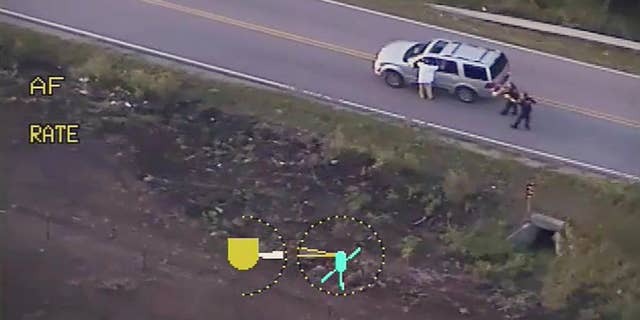 FILE - In this photo made from a Sept. 16, 2016 police video, Terence Crutcher, left, with his arms up is pursued by police officers as he walks next to his stalled SUV moments before he was shot and killed by one of the officers in Tulsa, Okla. Recent shootings by police raise a fundamental question: In the moments after officers shoot someone, how soon can medical aid be given? (Tulsa Police Department via AP, File)
