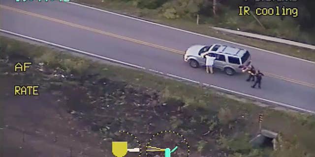 FILE - In this photo made from a Sept. 16, 2016 police video, Terence Crutcher, left, with his arms up is pursued by police officers as he walks next to his stalled SUV moments before he was shot and killed by one of the officers in Tulsa, Okla. Recent shootings by police raise a fundamental question: In the moments after officers shoot someone, how soon can medical aid be given? (Tulsa Police Department via AP, File)