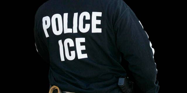 An Immigration and Customs Enforcement agent enters a restaurant to remove evidence in Cheektowaga, NY, April 16, 2008. 