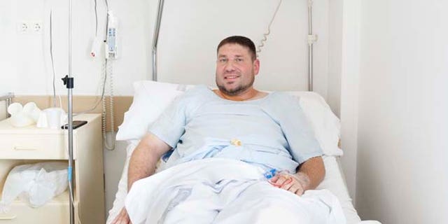 Mike Webster, a 38-year-old occupational therapist from Gainesville, Florida, who was gored in the armpit while running with the bulls in Pamplona for the 38th time over the last 11 years, poses for a picture on his hospital bed in Pamplona, Spain, Tuesday, July 7, 2015. Two Americans and a Briton were gored and eight others injured Tuesday as thousands of daredevils dashed alongside fighting bulls through the streets of this northern Spanish city on the first bull run of the San Fermin festival (AP Photo/Daniel Ochoa de Olza)