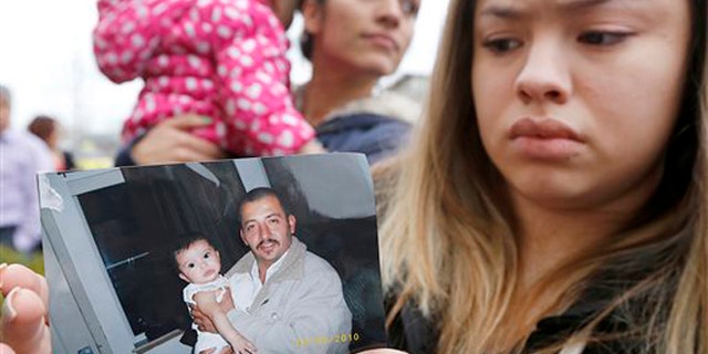 Erika Zambrano holds a 2010 photo of Antonio Zambrano-Montes, outside the city hall in Pasco, Wash.