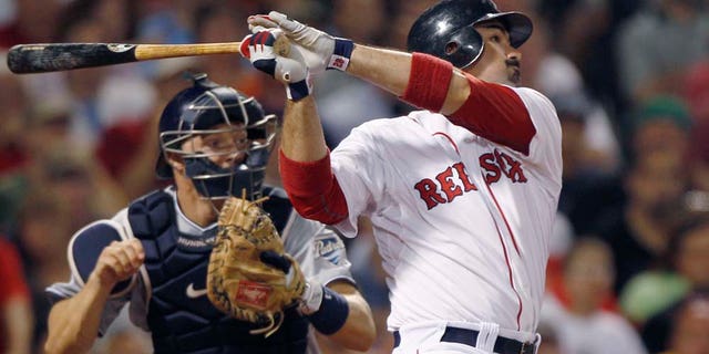 Boston Red Sox Adrian Gonzalez, right, and San Diego Padres catcher Nick Hundley watch Gonzalez's RBI double, breaking a 3-3 tie, in the bottom of the seventh inning of an interleague baseball game at Fenway Park in Boston, Monday, June 20, 2011. (AP Photo/Charles Krupa)