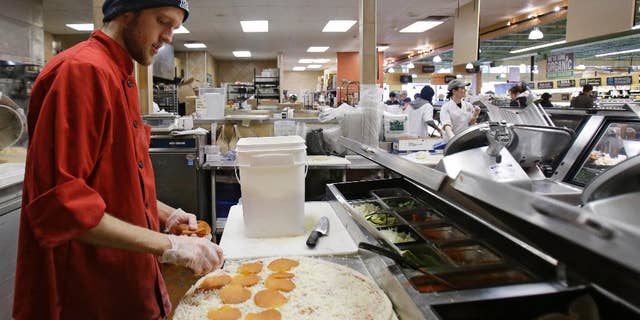 In this Thursday, March 27, 2014 John Pittenger makes a pepperoni pizza at the Whole Foods Market in Woodmere Village, Ohio. The Institute for Supply Management releases its service sector index for April 2015 on Tuesday, May 5, 2015. (AP Photo/Tony Dejak)