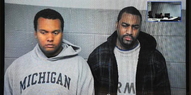 FILE- in this file image from Oct. 27, 2015, taken from video provided by the 36th District Court, Detroit police officers Charles Lynem, 28, left, and Chancellor Searcy, 31, are arraigned via video conference in Detroit. Detroit Police Chief James Craig says the two members of an elite police unit can return to work after being acquitted of stealing money from people they stopped on the street. A jury acquitted Officers Lynem and Searcy on Jan. 11, 2017. They had been suspended without pay. (Wayne County District Court/Detroit News via AP)