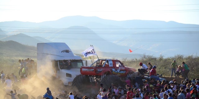 People run as an out of control monster truck plows through a crowd of spectators at a Mexican air show in the city of Chihuahua, Mexico, Saturday Oct. 5, 2013. According to authorities, at least 8 people were killed and 80 were injured. (AP Photo/El Diario de Chihuahua)
