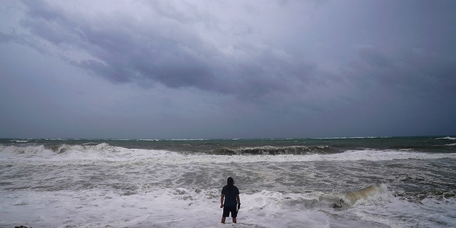 A man stands in the water at the beach ahead of Hurricane Irma's expected arrival in Fort Lauderdale, Florida, U.S., September 9, 2017. REUTERS/Carlo Allegri - RC12C86B5960