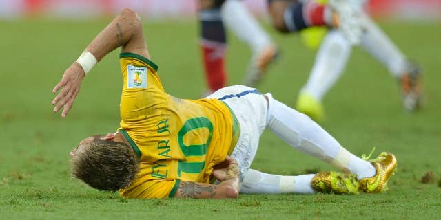 Brazil's Neymar holds his back after being fouled during the World Cup quarterfinal soccer match between Brazil and Colombia at the Arena Castelao in Fortaleza, Brazil, Friday, July 4, 2014. (AP Photo/Manu Fernandez)