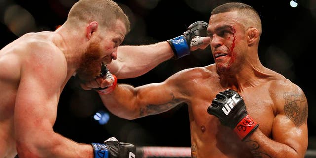 Vitor Belfort, right, of Brazil, trades blows with Nate Marquardt, of the United States, during their UFC middleweight mixed martial arts bout in Rio de Janeiro, Brazil, early Sunday, June 4, 2017. (AP Photo/Leo Correa)