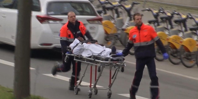 In this image taken from TV an injured person is evacuated as emergency services attend the scene after an explosion in a main metro station in Brussels.