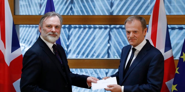 Britain's permanent representative to the European Union Tim Barrow, left, hand delivers British Prime Minister Theresa May's Brexit letter in notice of the UK's intention to leave the bloc under Article 50 of the EU's Lisbon Treaty to EU Council President Donald Tusk, in Brussels, Belgium, Wednesday, March 29, 2017. Barrow hand-delivered the letter signed by Britain's Prime Minister Theresa May that will formally trigger the beginning of Britain's exit from the European Union. (Yves Herman/Pool Photo via AP)