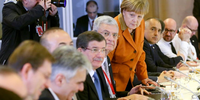 German Chancellor Angela Merkel, center, takes her seat during a lunch with other leaders at an EU summit in Brussels.