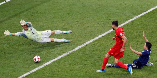 Belgium's Nacer Chadli scores the winning goal past Japanese keeper Eiji Kawashima in the World Cup last 16 match.